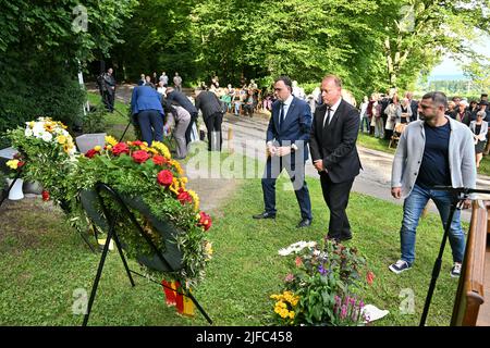 Baden Wuerttemberg, Germania. 01st luglio 2022. 01 luglio 2022, Baden-Wuerttemberg, Brachenreuthe bei Überlingen: Decine di persone commemorano le vittime dell'incidente aereo 20 anni fa a Brachenreuthe, mentre rappresentanti della città, dello stato e dei parenti si trovano di fronte alle corone. Da destra: Taras Kostenko, russo di Charkiv in Ucraina, Jan Zeitler, sindaco di Überlingen e segretario di Stato Siegfried Lorek. La collana di perle lacerate, come si chiama l'opera d'arte commemorativa, commemora l'incidente aereo il 1 luglio 2002 vicino a Überlingen. A quel tempo, 71 persone sono state uccise durante la collisione Foto Stock