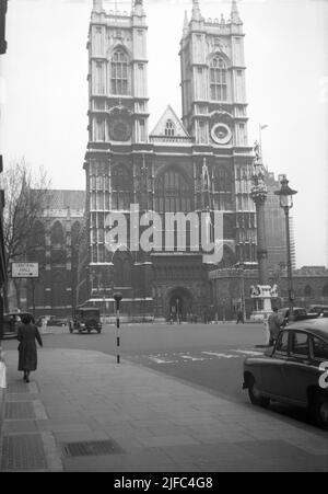 1952, vista storica, dall'esterno di Westminster Abbey, Londra, Inghilterra, Regno Unito, fuliggine coperta in quest'era del dopoguerra. Dal 1066, sede di tutte le nazioni dei monarchi inglesi e britannici, la chiesa è di proprietà diretta della famiglia reale Briitsh. Cartello per il Central Hall sulla sinistra, un Metodista Central Hall che ha aperto nel 1912 e dove si svolgono dibattiti ed eventi. Foto Stock