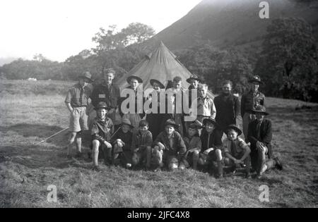 1954, storico, nebbia sulla montagna in un campo scout a Glen Nevis, Highland, Scozia, Regno Unito, come i giovani scout si riuniscono per un quadro di gruppo da una tenda. Foto Stock