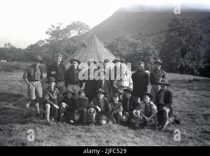 1954, storico, nebbia sulla montagna in un campo scout a Glen Nevis, Highland, Scozia, Regno Unito, come i giovani scout si riuniscono per un quadro di gruppo da una tenda. Foto Stock