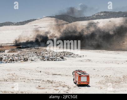 Incendio in uno scarico pneumatico. Fumo nero intenso proveniente dalla combustione dei vecchi pneumatici Foto Stock