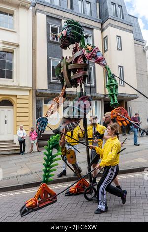 Winchester Hat Fair, 1st luglio 2022. L'annuale Fiera del cappello è iniziata oggi con le scuole locali che hanno preso parte alla processione del Carnevale attraverso il centro della città con i bambini vestiti con i costumi colorati. Winchester Hat Fair è un festival di arti all'aperto della durata di 3 giorni, con artisti di strada e spettacoli in diversi luoghi della città. EKO, un marionetta gigante alto 13 metri nella processione di carnevale. Foto Stock