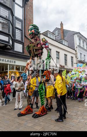 Winchester Hat Fair, 1st luglio 2022. L'annuale Fiera del cappello è iniziata oggi con le scuole locali che hanno preso parte alla processione del Carnevale attraverso il centro della città con i bambini vestiti con i costumi colorati. Winchester Hat Fair è un festival di arti all'aperto della durata di 3 giorni, con artisti di strada e spettacoli in diversi luoghi della città. EKO, un marionetta gigante alto 13 metri nella processione di carnevale. Foto Stock