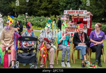 Winchester Hat Fair, 1st luglio 2022. L'annuale Fiera del cappello è iniziata oggi con le scuole locali che hanno preso parte alla processione del Carnevale attraverso il centro della città con i bambini vestiti con i costumi colorati. Winchester Hat Fair è un festival di arti all'aperto della durata di 3 giorni, con artisti di strada e spettacoli in diversi luoghi della città. Persone anziane con cappelli di fantasia godendo l'intrattenimento in Abbey Gardens. Foto Stock