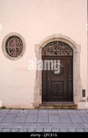 Porta ad arco circolare realizzata con arte in un edificio storico in Piazza Manghaus, nella città vecchia di Memmingen, nella regione della bassa Allgäu, in Baviera, Germania. Foto Stock