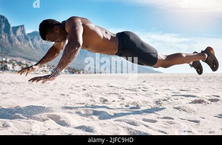 Fit giovane uomo nero che fa asse tenere esercizi sulla sabbia alla spiaggia al mattino. Atleta afro americano muscolare maschile bodybuilder fare Foto Stock