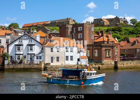 Whitby, Regno Unito - Giugno 10th 2022: Una barca da pesca che naviga sul fiume Esk nella splendida cittadina balneare di Whitby nel North Yorkshire, Regno Unito. Foto Stock