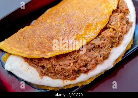 Cachapa con carne tirata, tortilla di mais con formaggio, carne e burro Foto Stock