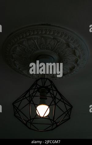 Lampada di montaggio hipster in metallo appeso montaggio intorno a lampadina elettrica con soffitto d'epoca Foto Stock