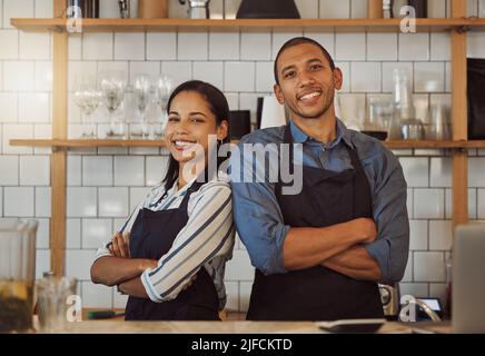 I partner aziendali si levano in piedi indietro nel loro coffeeshop. I colleghi del ristorante sono vicini l'uno all'altro. Ritratto di due imprenditori braccia Foto Stock