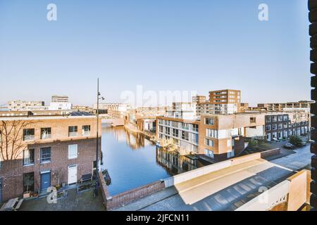 Vista panoramica della città, case, canale e ponte e cielo blu in una giornata di sole Foto Stock