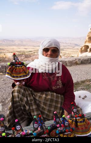 Venditore di souvenir che vende bambole tradizionali nel villaggio di Uchisar, regione della Cappadocia, Turchia. Foto Stock