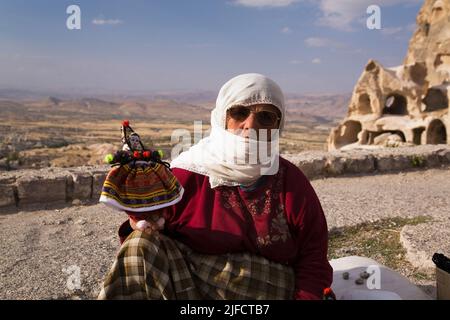 Venditore di souvenir che vende bambole tradizionali nel villaggio di Uchisar, regione della Cappadocia, Turchia. Foto Stock