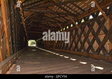 In copertina: Design architettonico dell'interno del lungo Scott Bridge a Townshend, Vermont. Luce, ombra e travi di legno. Costruito nel 1870. Foto Stock