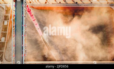 Mais in blocco portarinfuse. Contenitore per il pezzo fuso del mais. I carichi della gru elevatore trasportano il portarinfuse con il mais ucraino Foto Stock