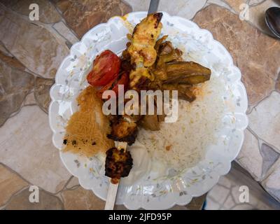 JUDJEH KEBAB spiedini di pollo alla griglia e spiedini di pomodoro su riso Foto Stock