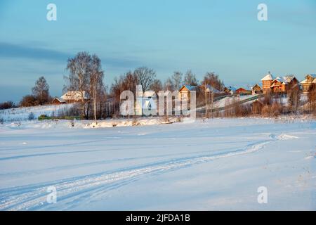 Tracce di veicoli e persone sul fiume Volga ghiacciato e innevato Foto Stock