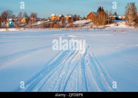 Tracce di veicoli e persone sul fiume Volga ghiacciato e innevato Foto Stock