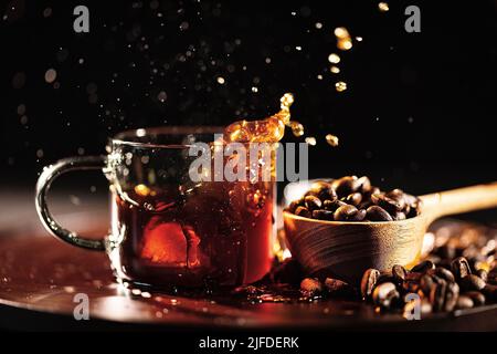 Aggiungendo cubetti di ghiaccio al caffè nero, il tradizionale processo di preparazione del caffè artigianale - foto di scorta Foto Stock