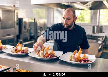 Ristorante dell'hotel, chef privato che prepara antipasti. Ristoranti e cucina raffinata. Foto Stock