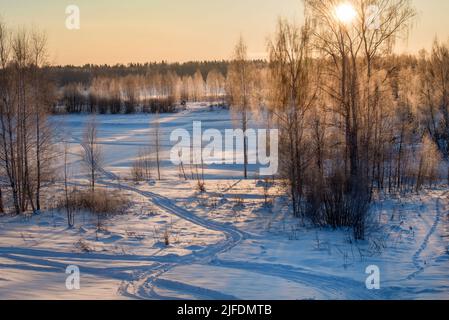 Tracce di veicoli e persone sul fiume Volga ghiacciato e innevato Foto Stock