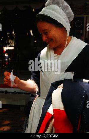 Una donna adulta si veste come Betsy Ross a Philadelphia e dimostra ai visitatori come le prime bandiere americane sono state create Foto Stock