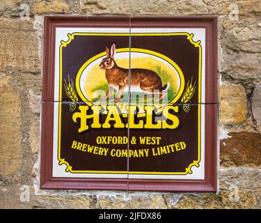 Chipping Norton, UK - Aprile 10th 2022: Old Sign Promoting Halls Brewery Company, situato all'esterno di un edificio nella città di Chipping Norton, Foto Stock