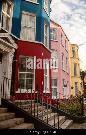 Frontone con porta a triangolo in stile georgiano e finestre a bovindo in stile vittoriano su case terrazzate a Portrush, Irlanda del Nord. Foto Stock