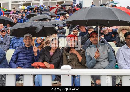 I fan si srotolano sotto le loro brullie mentre la pioggia si ferma per una seconda volta Foto Stock