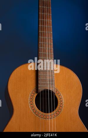 Chitarra classica spagnola su uno sfondo blu spettacolare con spazio copia Foto Stock