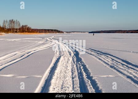 Tracce di veicoli e persone sul fiume Volga ghiacciato e innevato Foto Stock