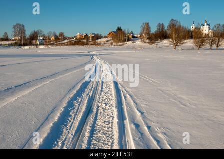 Tracce di veicoli e persone sul fiume Volga ghiacciato e innevato Foto Stock
