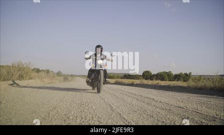 moto personalizzata sulla strada. divertirsi guidando la strada vuota in un viaggio in moto. Motociclista corre su una strada rocciosa. Foto Stock