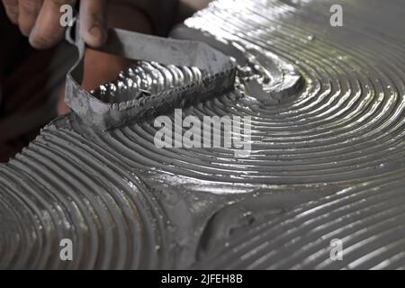 Primo piano dello scultore maschio che tiene l'attrezzo e che fa l'arte sull'argilla. Matrice di stampaggio di creta. Modellazione di argilla. Foto Stock