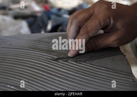 Primo piano dello scultore maschile che fa arte su argilla usando le mani. Matrice di stampaggio di creta. Modellazione di argilla. Foto Stock