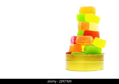 Grande gruppo di caramelle di gelatina di frutta impilate in una scatola rotonda di lattina isolata su bianco. Foto Stock