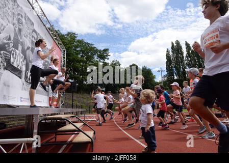 Bruxelles, Belgio. 02nd luglio 2022. La Francia ha passato il batone relè simbolicamente alla Repubblica ceca per la sua presidenza UE di inizio in una gara atletica che porta il nome del leggendario atleta ceco Emil Zatopek, un quattro volte vincitore olimpico a lunga distanza, con 400 partecipanti oggi, sabato 2nd luglio 2022. La gara di cinque chilometri si è svolta presso lo Stade des Trois Tilleuls (stadio dei tre Linden), dove Zatopek ha stabilito un nuovo record mondiale nella corsa di 10 chilometri nel 1954. Gli Olympians cechi guidano un warm-up prima della corsa dei bambini. Credit: Petr Kupec/CTK Photo/Alamy Live News Foto Stock