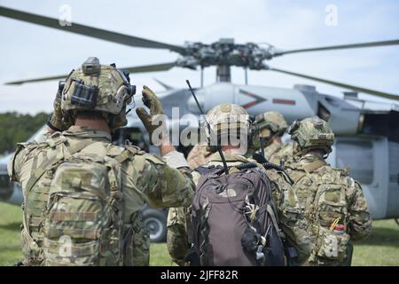 VIRGINIA BEACH, Virginia (Jun. 29, 2022)- i tecnici di Explosive Ordnance Disposal (EOD) della Explosive Ordnance Disposal Mobile Unit (EODMU) 6 si preparano a salire a bordo di un elicottero SH-60s Sea Hawk assegnato allo squadrone di combattimento Elicottero Sea Combat (HSC) 9 per condurre un rapido inserimento della corda. CRABEx è un esercizio di formazione che certifica le unità d'azione della Marina EOD nell'ambito del gruppo di smaltimento delle sostanze esplosive (EODGRU) 2, garantendo una forza EOD pronta e più letale. Foto Stock