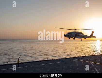 220529-N-TI693-2103 MAR MEDITERRANEO (29 maggio 2022) - Aviation Boatswain's Mate (Handling) 1st Classe Michael Duffy, da Philadelphia, segnala un elicottero MH-60R di decollo dal ponte di volo a bordo della base marittima di spedizione di Lewis B. Puller-class USS Hershel 'Woody' Williams (ESB 4) durante l'esercizio Phoenix Express 22, 29 maggio 2022. Phoenix Express 22, condotta dalle forze Navali degli Stati Uniti Africa, è un esercizio marittimo progettato per migliorare la cooperazione tra le nazioni partecipanti al fine di aumentare la sicurezza e la sicurezza marittima nel Mediterraneo. (STATI UNITI Foto Navy di Mass Communication Spe Foto Stock