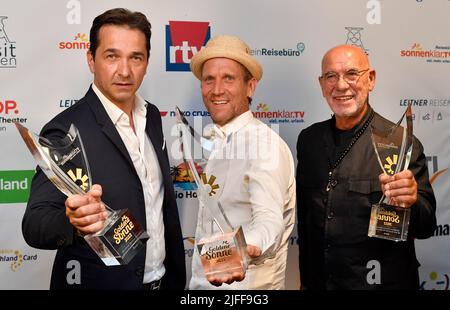 Essen, Germania. 02nd luglio 2022. I vincitori della categoria 'Series', gli attori Andreas Elsholz (l-r), Peer Kusmagk e otto Retzer, attore e regista austriaco, mostrano il loro premio al gala 'Goldene Sonne' che celebra il 40th° anniversario della televisione privata al Teatro GOP Varieté. Credit: Roberto Pfeil/dpa/Alamy Live News Foto Stock