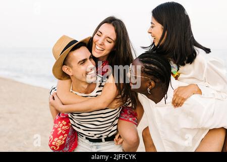 Giovani amici multirazziali che si godono una giornata in spiaggia nelle vacanze estive Foto Stock