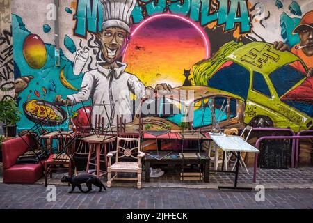 Marsiglia, Francia, maggio 2022, vista di alcune sedie e tavoli accatastati di fronte a un murale nel quartiere le Panier Foto Stock