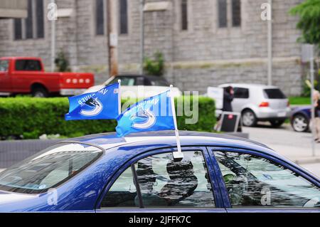 Vancouver, Canada - 17 giugno 2011: Vancouver Canucks bandiere professionali di squadra di hockey su ghiaccio sulla parte superiore dell'automobile. Foto Stock