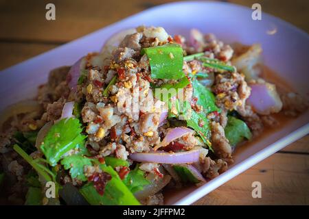 Cibo tailandese, insalata di maiale piccante tritata (Larb Moo) su piatto bianco Foto Stock