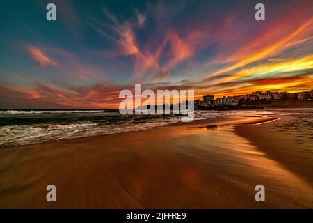 Splendidi cieli colorati mentre il sole sorge sulla famosa Bondi Beach a Sydney, Australia. Guardare a sud sulla sabbia deserta è magico Foto Stock