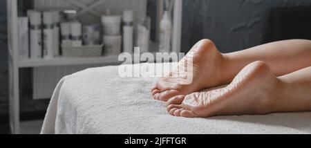 Massaggio benessere donna ai piedi da parte di un massaggiatore professionista presso il centro benessere. Concetto di benessere, di sollievo dallo stress e di ringiovanimento. Cura del corpo Foto Stock