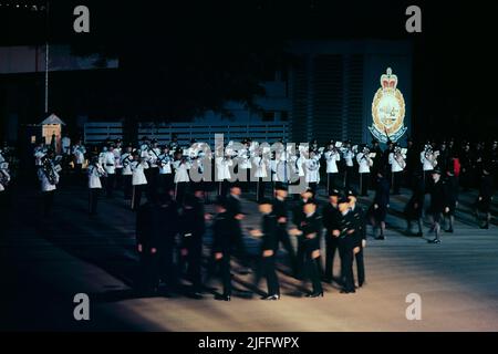 “Sconfiggere il ritiro” Parata coloniale sotto i riflettori, presso la Scuola di formazione della polizia di Hong Kong (ora “Accademia di polizia”), Aberdeen, Hong Kong, Cina, novembre 1992 Foto Stock