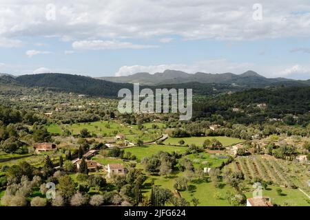 Mallorca - Vista dal Santuari de Sant Salvador in Artà in direzione nord-ovest, ampio paesaggio con prati, campi, alberi, colline e una rla di montagna Foto Stock