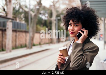 giovane donna d'affari latina che parla al telefono Foto Stock