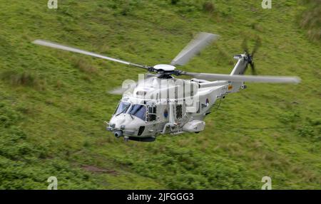 Royal Netherlands Navy, NH90 Helicopter in distacco nel Regno Unito a RNAS Culdrose, che effettua un addestramento di volo di basso livello nella zona di Mach Loop di Wale Foto Stock